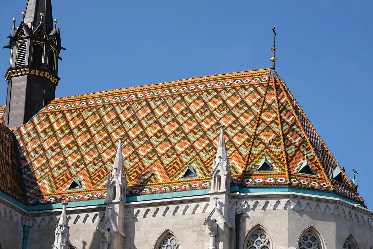 The eastern end of Matthias Church under a roof of diamond-pattern coloured tiles, with stone pinnacles and a dark turret